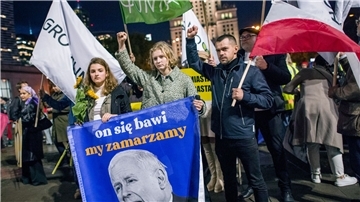 Demonstrierende halten eine Fahne mit dem Abbild von Jaroslaw Kaczynski. Hunderte Menschen zogen durch die Straßen Warschaus, um gegen die Politik der Regierung zu demonstrieren.