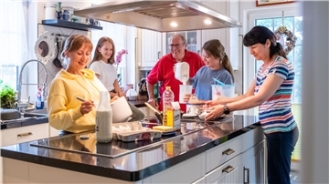 Den Alltag versüßen: Liudmyla, Kristina, Zarina und Nina bereiten mit Gastgeber Thomas Lang in der heimischen Küche in Langen einen Pfannkuchen nach ukrainischem Rezept zu.