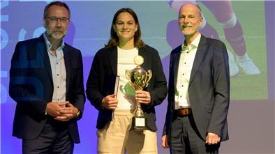 Eine junge Frau steht mit einem Pokal zwischen zwei Männern. Giovanna Hoffmann ist Bremerhavens "Sportlerin des Jahres 2024". 