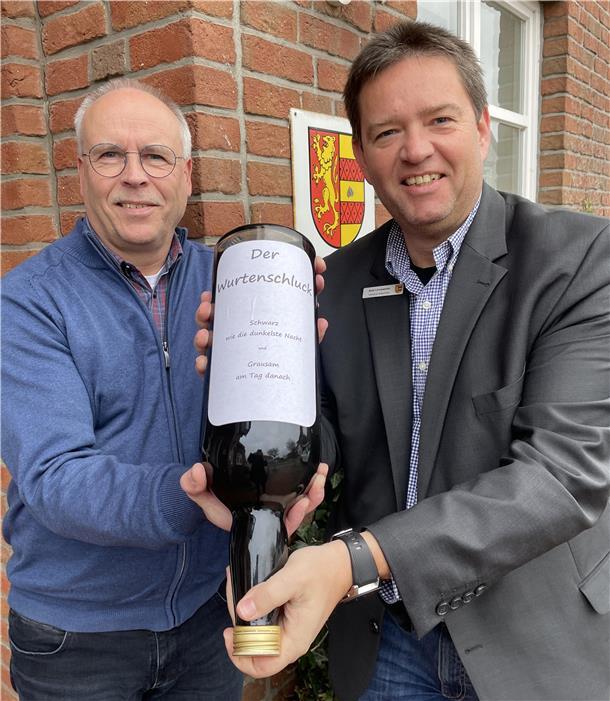 Den Wurtenschluck, den Stefan Stührenberg vom Bauamt und Bürgermeister Axel Linneweber hier präsentieren, hat die Verwaltung vor Jahren bei einem Boßelwettkampf gewonnen. 