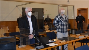 Zwei Männer stehen in einem Gerichtssaal. 