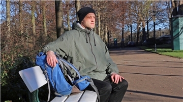 Ein Mann auf einer Parkbank am Hollersee in Bremen.