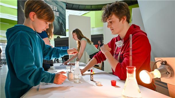 Der 8-jährige Klimahaus-Besucher Sven beobachtet gespannt das Experiment. Meteorologie-Student Johann Fechner erklärt ihm, was passiert.