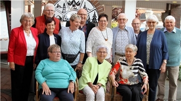 Mehrere Menschen haben sich für ein Gruppenfoto positioniert.