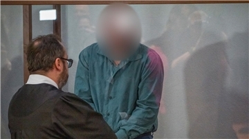 Der Angeklagte bespricht sich im Gerichtssaal mit seinem Rechtsanwalt.