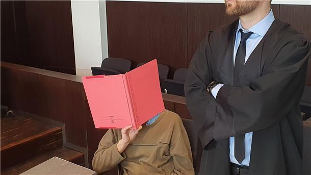 Der Angeklagte (l) sitzt neben seinem Verteidiger Maximilian Klefenz im Verhandlungssaal des Düsseldorfer Landgerichts und verdeckt sein Gesicht.