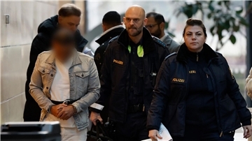Der Angeklagte (l) wird in Handschellen zum Sitzungssaal im Landgericht Würzburg gebracht.