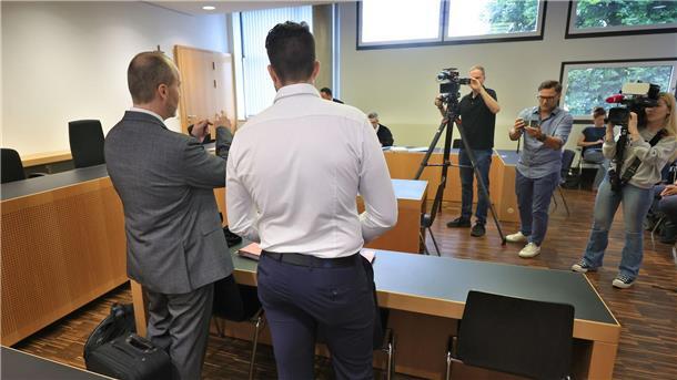 Polizist nach Schuss aus Dienstwaffe verurteilt Der Angeklagte (Mitte) steht mit seinem Anwalt im Verhandlungssaal.