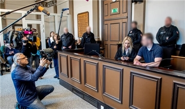 Der Angeklagte sitzt neben seiner Verteidigerin im Landgericht Verden und wird von Medienvertretern gefilmt.