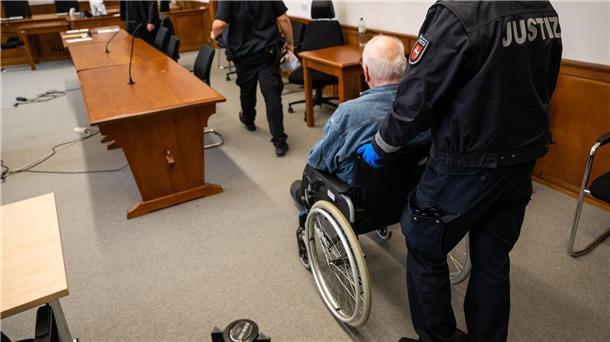 Lebenslang für 79-Jährigen wegen Mordes an Ehefrau Der Angeklagte wird im Rollstuhl in den Saal des Landgerichts geschoben.