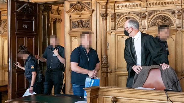 Der Angeklagte wird von Justizvollzugsbeamten in den Verhandlungssaal geführt.