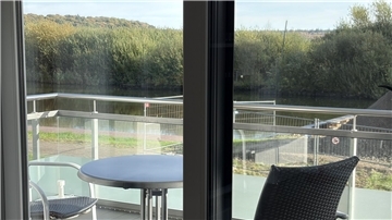 Blick vom Balkon auf das Ufer am Kanal