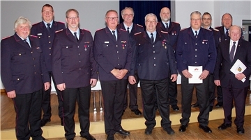 Der ausgeschiedene Kreisbrandmeister Heiko Basshusen und sein Nachfolger Ralf Hoyer ehrten Thomas Hülsebusch, Heinz Bielefeld, Jens Cordes, Uwe Menke, Stefan Hobbie, Thomas Luerssen, Bernd Kempendorf, Klaus Braje und Günter Busch (von links). Foto: Flor