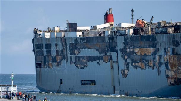 Der Autofrachter „Fremantle Highway“ wird an Schaulustigen vorbei in den Hafen gezogen.