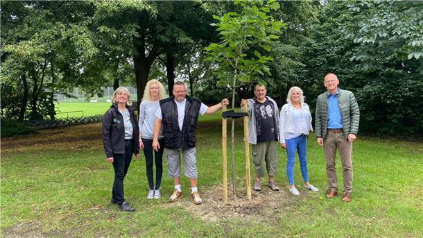 Der Baum wurde im Beisein von Klimaschutzmanagerin Anne Böttjer, Einrichtungsleiterin Marion Haase, Bewohner Bernd Warnke, Bewohner Ralf Kleilein, Bewohnerin Ramona Kreuzberg und Bürgermeister Detlef Wellbrock (v. l.) gepflanzt.