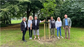 Der Baum wurde im Beisein von Klimaschutzmanagerin Anne Böttjer, Einrichtungsleiterin Marion Haase, Bewohner Bernd Warnke, Bewohner Ralf Kleilein, Bewohnerin Ramona Kreuzberg und Bürgermeister Detlef Wellbrock (v. l.) gepflanzt.