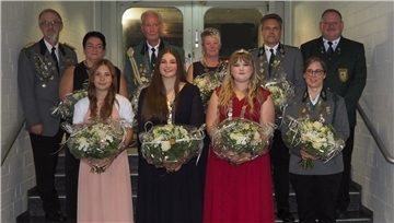 Gruppenfoto von sechs Frauen und vier Männern auf einer Treppe.