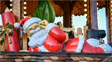 Weihnachtsmannfigur auf dem Dach lacht.