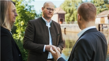 Das Foto zeigt Marco Mohrmann im Gespräch mit zwei Personen. 