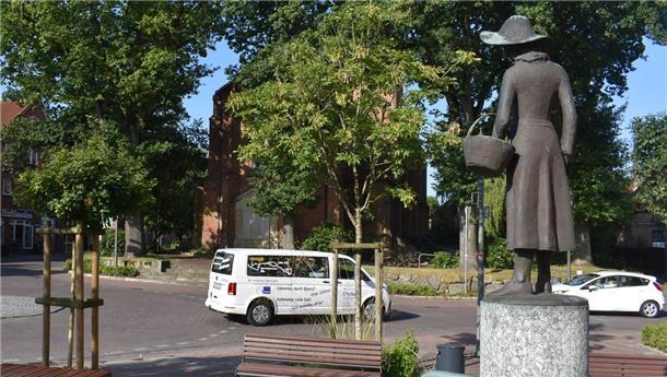 Ein Bus, ein Auto und eine Skulptur