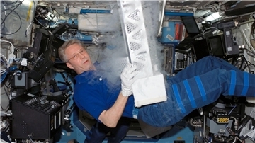 Der deutsche Astronaut Thomas Reiter an Bord der Internationalen Raumstation ISS: Hier hantiert er mit Teilen einer Laborgefriereinrichtung.