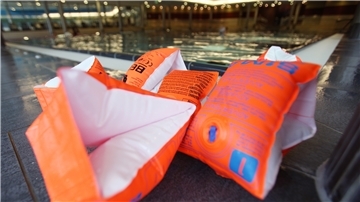 Schwimmflügel für Kinder liegen vor einem Schwimmkurs im "Festland" Bad in Hamburg am Beckenrand.