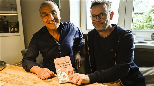 Zwei Männer sitzen an einem Tisch, lächeln und zeigen ein Buch. Der dritte Band der Trilogie von Samer Tannous (links) und Gerd Hachmöller soll die letzte gemeinsame Veröffentlichung der Kolumnen sein.