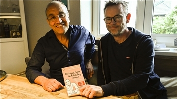 Zwei Männer sitzen an einem Tisch, lächeln und zeigen ein Buch. Der dritte Band der Trilogie von Samer Tannous (links) und Gerd Hachmöller soll die letzte gemeinsame Veröffentlichung der Kolumnen sein.