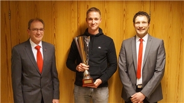 Der ehemalige TSV-Vorsitzende Bernd Sandfuchs (links) und Sportwart Jan Sandfuchs (rechts) überreichten André Köster den Siegerpokal. 