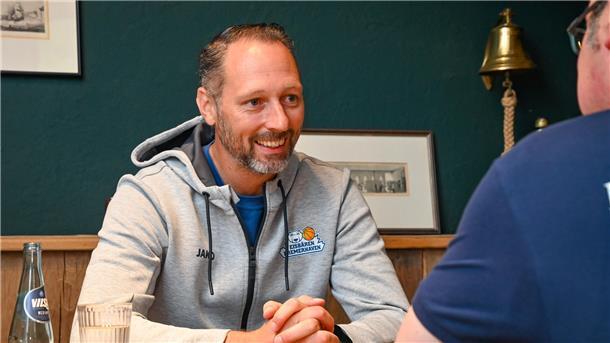 Ein Basketball-Trainer lacht, während er ein Interview gibt. Es ist Steven Esterkamp von den Eisbären Bremerhaven.