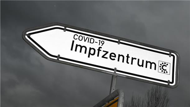 Ein Hinweisschild mit der Aufschrift «Covid-19 Impfzentrum» ist nahe des Impfzentrums an einer Straße platziert.