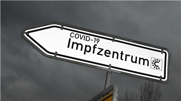 Ein Hinweisschild mit der Aufschrift «Covid-19 Impfzentrum» ist nahe des Impfzentrums an einer Straße platziert.