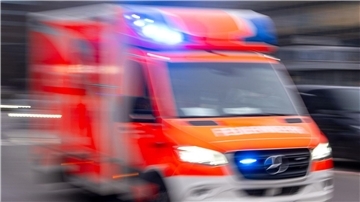 Ein Rettungswagen der Feuerwehr fährt mit Blaulicht zum Einsatz (Aufnahme mit Langzeitbelichtung). 