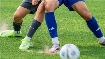 Zwei Fußballer kämpfen um den Ball.