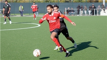 Zwei Fußballer rennen einem Ball hinterher.