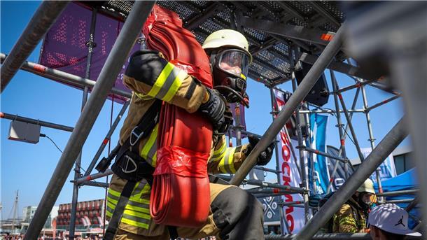 Feuerwehrleute treten im Wettkampf gegeneinander an Der Feuerwehrmann Philipp Reumann von der Freiwilligen Feuerwehr Eckwarden steigt bei der „Firefighter Combat Challenge“ in Bremerhaven mit einem Schlauch auf einen Turm.