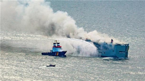 Der Frachter „Fremantle Highway“ steht in Flammen. Ein Notschlepper (l) bekämpft das Feuer.