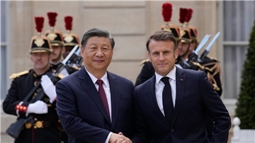 Der französische Präsident Emmanuel Macron (r) begrüßt Chinas Präsident Xi Jinping vor ihrem Treffen im Elysee-Palast.