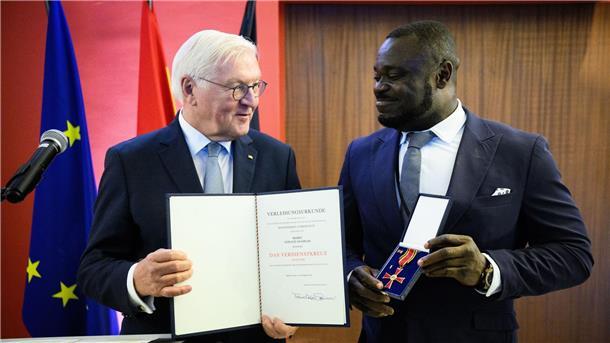 Der frühere Fußball-Nationalspieler Gerald Asamoah (r) erhält von Bundespräsident Frank-Walter Steinmeier das Bundesverdienstkreuz.