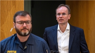 Der früheren Wirecard-Vorstandschef Markus Braun (r) wird von einem Justizbeamten in den Gerichtssaal begleitet (Archivbild).