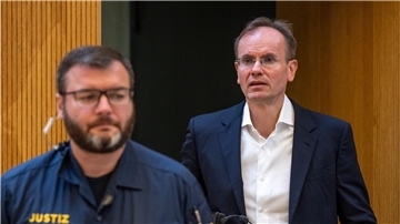 Der früheren Wirecard-Vorstandschef Markus Braun wird von einem Justizbeamten in den Gerichtssaal begleitet.