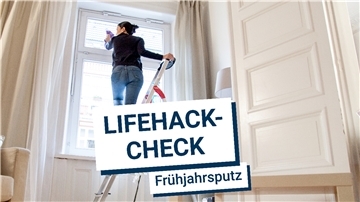 Eine Frau steht auf einer Leiter und putze ein Fenster.