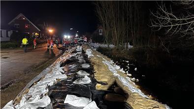 Der in Brauel mit Sandsäcken verstärkte Deich schützt die umliegenden Häuser vor Wasser.