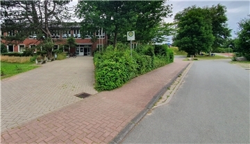 Ein Schulgebäude an einer Straße.