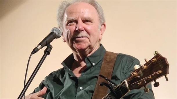 Ein Mann mit Gitarre am Mikrofon.