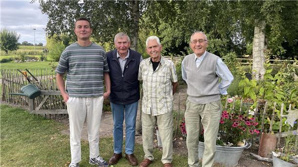 Ein junger und drei ältere Männer stehen nebeneinander.