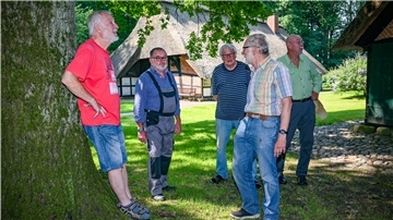Männer stehen auf einem Bauernhaus-Grundstück
