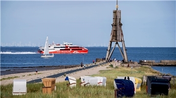 Der Katamaran „Halunder Jet“ der Reederei FRS Helgoline passiert bei sonnigem Wetter die Kugelbake in Cuxhaven. Für das Schiff, das Helgoland mit dem Festland verbindet, beginnt die Saison am 27. März.
