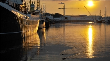 Ein Schiff liegt bei Sonnenuntergang im Fischereihafen Bremerhaven.