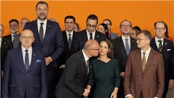 Der kroatische Außenminister Gordan Grlic Radman begrüßt Annalena Baerbock mit einen Kuss beim Gruppenbild im Rahmen der Europakonferenz in Berlin.
